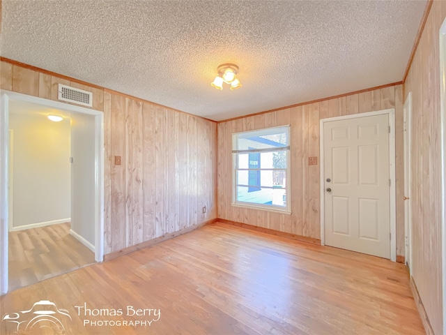 unfurnished room featuring hardwood / wood-style flooring and a textured ceiling