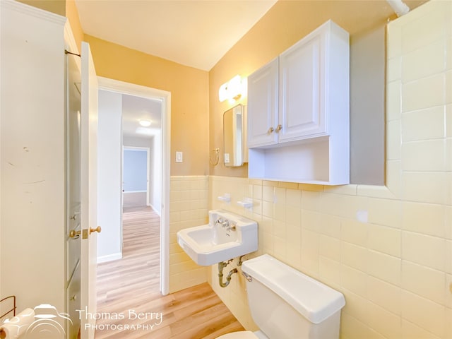 bathroom featuring hardwood / wood-style floors, sink, tile walls, and toilet