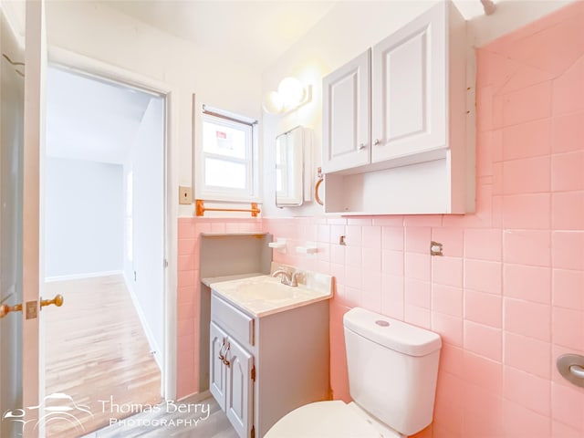 bathroom with vanity, tile walls, and toilet