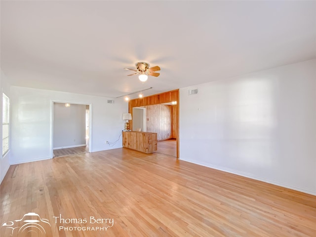 unfurnished living room featuring ceiling fan and light hardwood / wood-style flooring