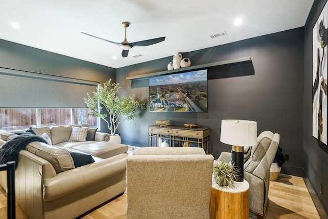 home theater with ceiling fan and light hardwood / wood-style flooring