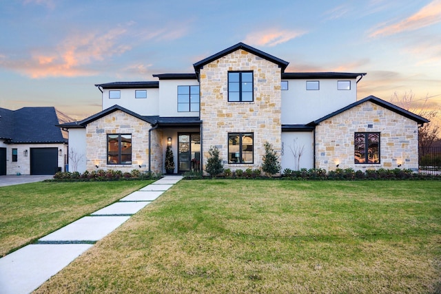 contemporary house featuring stone siding, stucco siding, and a garage