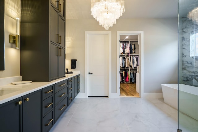 bathroom featuring vanity, a chandelier, and a tub