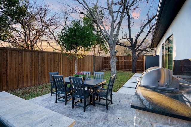 patio terrace at dusk featuring exterior kitchen