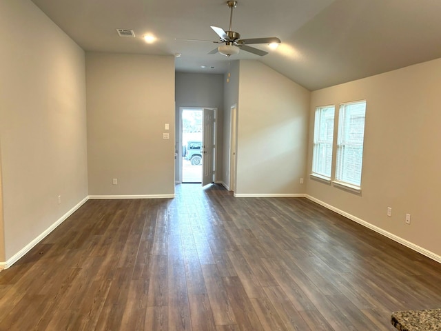 empty room featuring dark wood-type flooring, ceiling fan, a healthy amount of sunlight, and vaulted ceiling