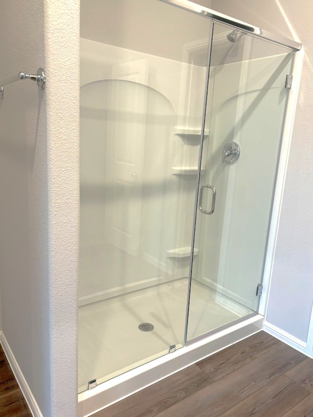 bathroom featuring hardwood / wood-style flooring and an enclosed shower