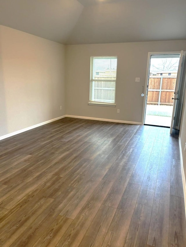 empty room with lofted ceiling and dark hardwood / wood-style floors