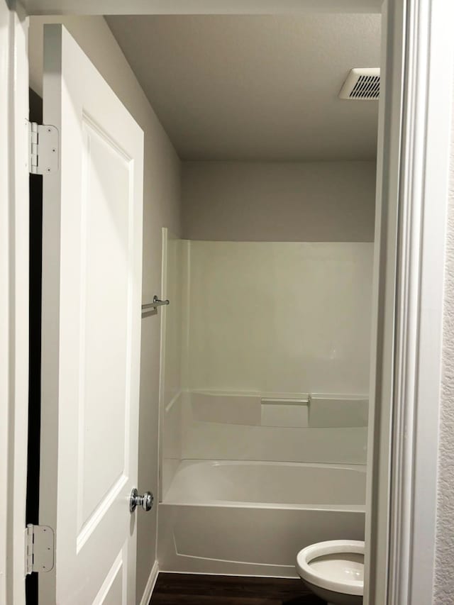 bathroom with hardwood / wood-style floors and toilet