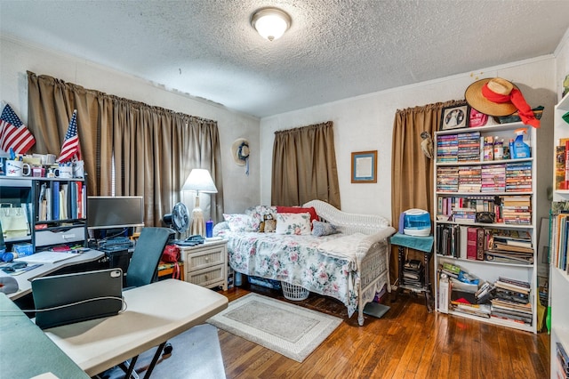 bedroom featuring dark hardwood / wood-style flooring and a textured ceiling