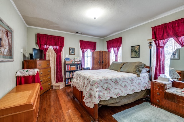 bedroom with dark hardwood / wood-style flooring, ornamental molding, and a textured ceiling