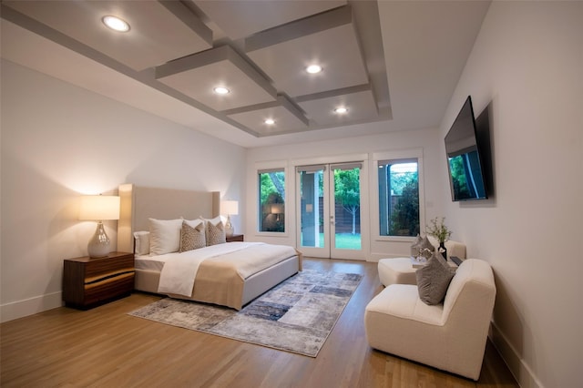 bedroom featuring light hardwood / wood-style floors, access to exterior, french doors, and coffered ceiling