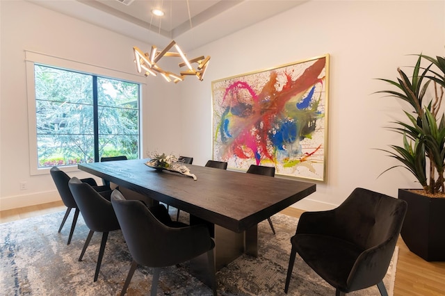 dining space with light hardwood / wood-style flooring and an inviting chandelier