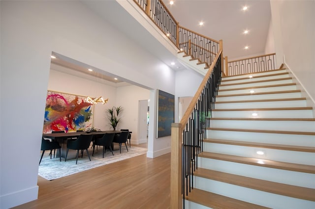 stairway with hardwood / wood-style flooring and a high ceiling