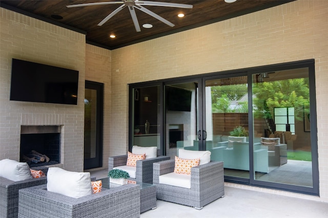 view of patio / terrace featuring ceiling fan and an outdoor living space with a fireplace