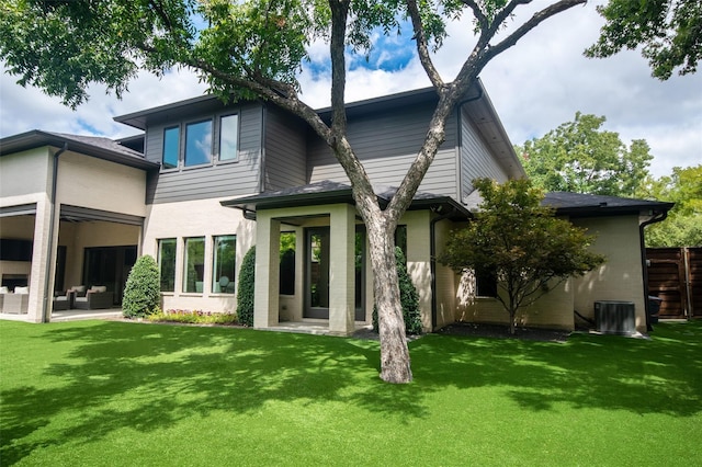 rear view of house with an outdoor hangout area, a patio area, a yard, and cooling unit