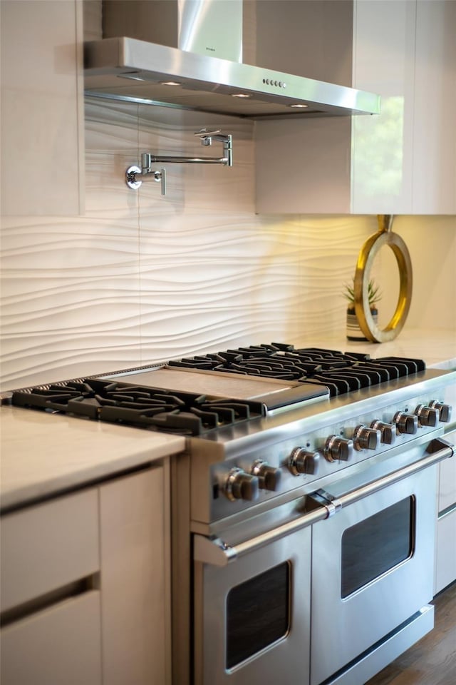 kitchen featuring white cabinetry, double oven range, dark hardwood / wood-style floors, and wall chimney exhaust hood