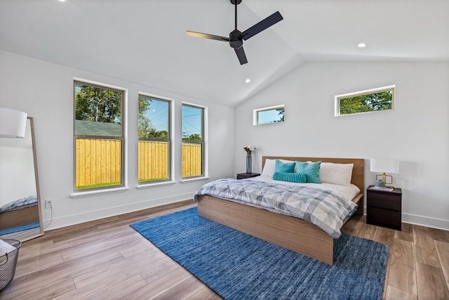 bedroom with ceiling fan, light hardwood / wood-style flooring, and vaulted ceiling