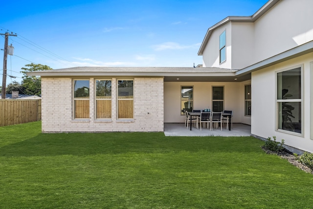 back of property with a patio area and a lawn