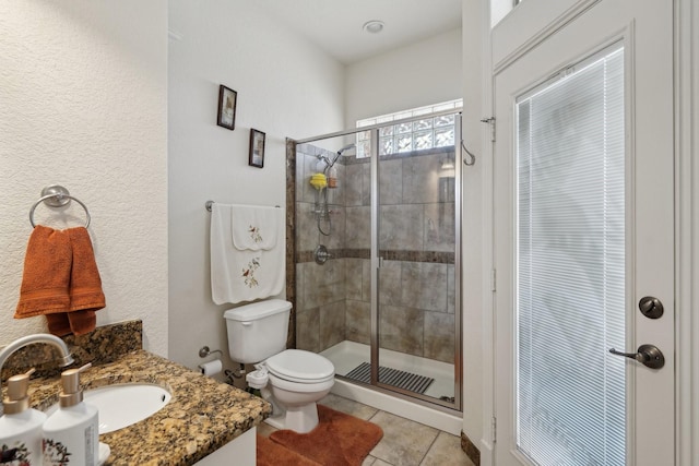 bathroom with walk in shower, vanity, toilet, and tile patterned flooring