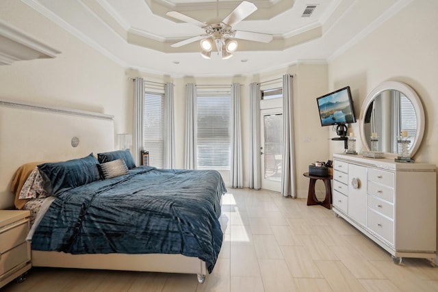 bedroom with ceiling fan, a raised ceiling, crown molding, and multiple windows