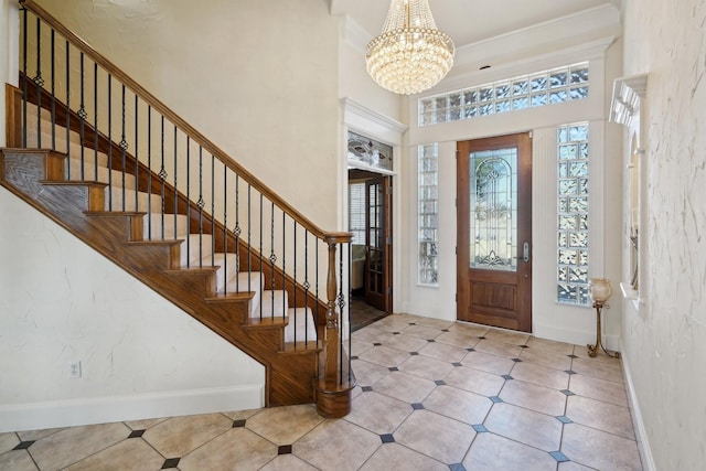 entrance foyer with crown molding, a high ceiling, and a notable chandelier