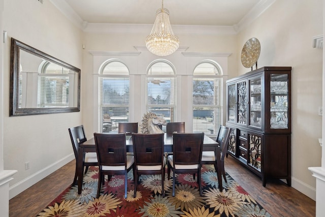 dining area with crown molding, dark wood-type flooring, and a chandelier