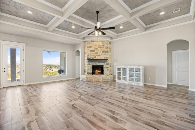 unfurnished living room featuring beamed ceiling, ornamental molding, a towering ceiling, and coffered ceiling