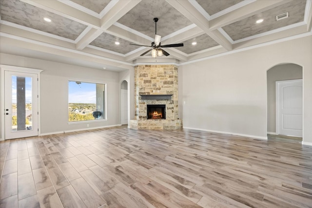 unfurnished living room featuring coffered ceiling, a high ceiling, ornamental molding, and light hardwood / wood-style floors