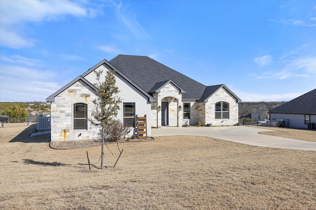 french country home featuring a front lawn