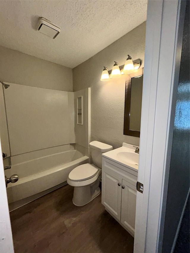 full bathroom featuring a textured ceiling, wood-type flooring, vanity, toilet, and shower / bathtub combination