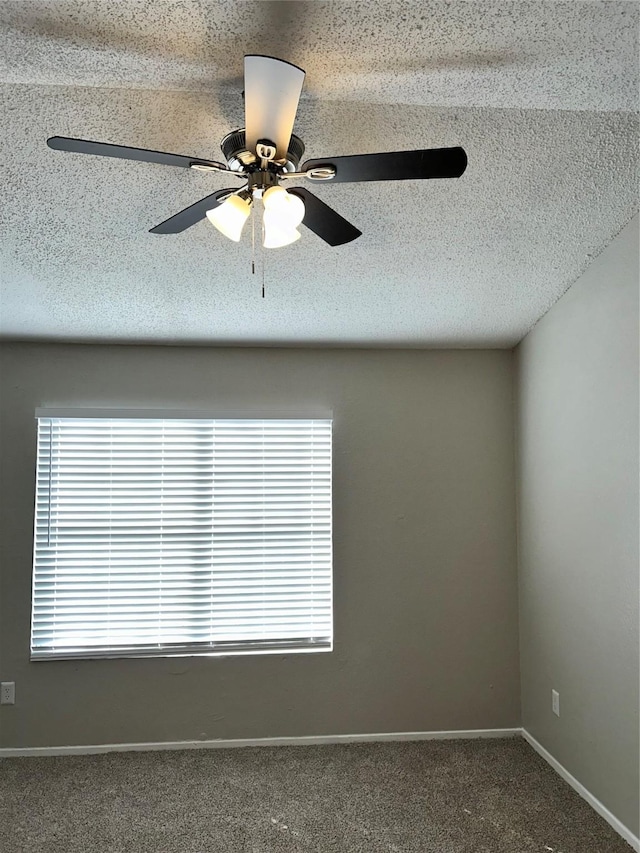 spare room with ceiling fan and dark carpet