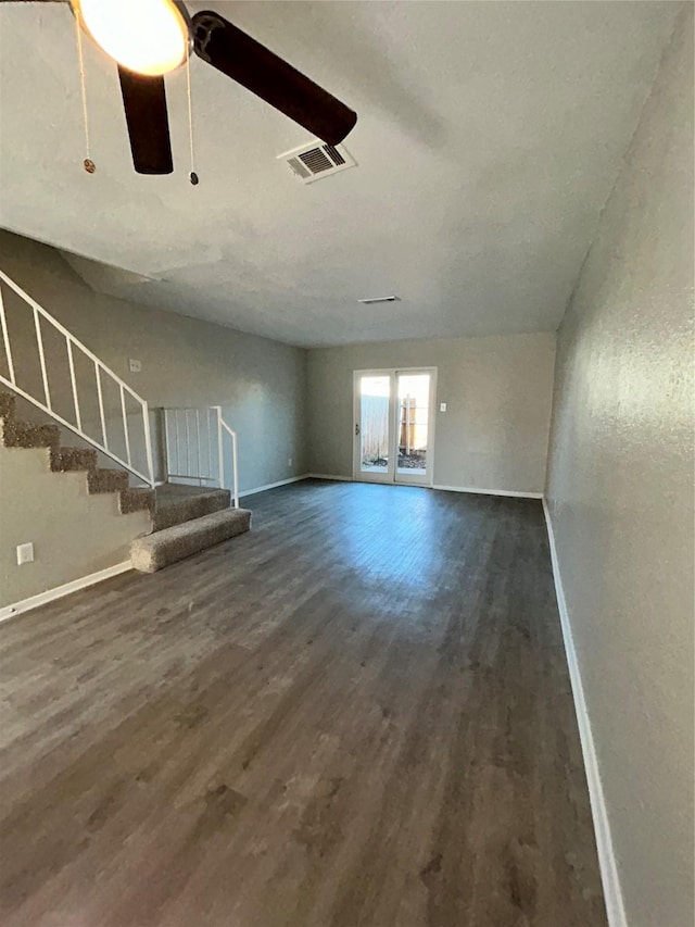 unfurnished living room featuring ceiling fan and dark wood-type flooring