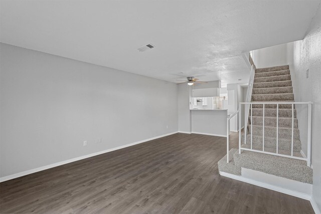 empty room with dark hardwood / wood-style floors and a textured ceiling