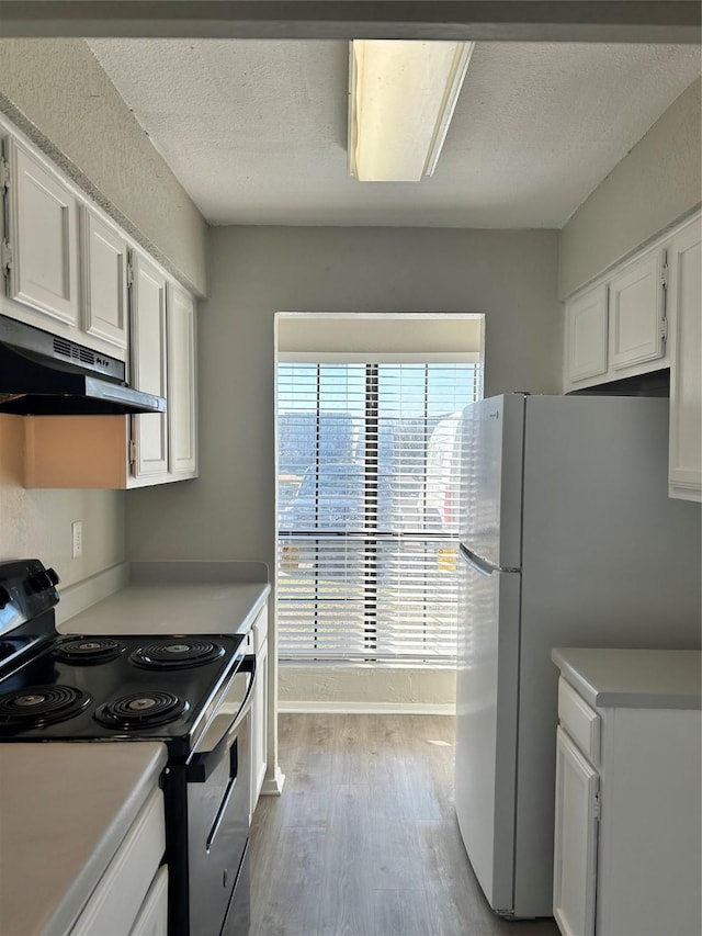 kitchen featuring white refrigerator, light wood-type flooring, white cabinetry, electric stove, and a textured ceiling