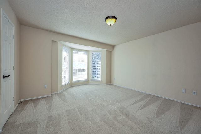 carpeted empty room featuring a textured ceiling