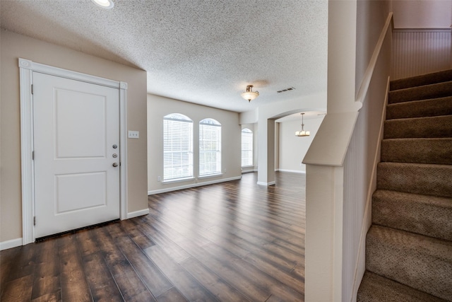 foyer entrance featuring dark wood-type flooring and a textured ceiling