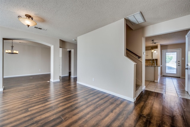 unfurnished living room featuring dark hardwood / wood-style floors and a textured ceiling