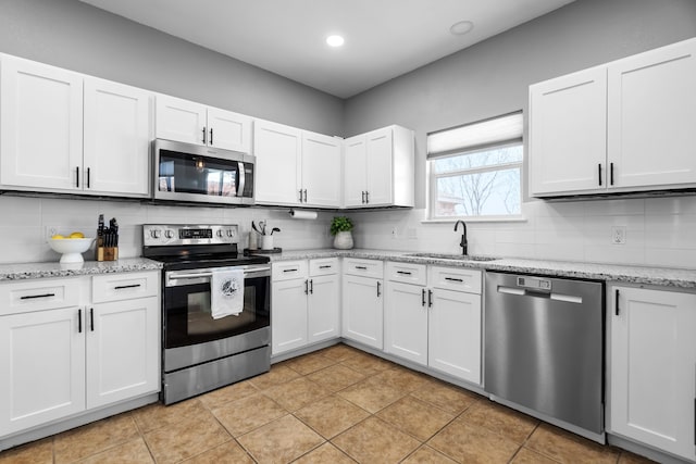 kitchen featuring light tile patterned floors, sink, white cabinets, and appliances with stainless steel finishes