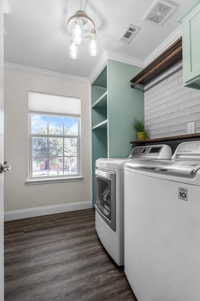 clothes washing area featuring ornamental molding, cabinets, and separate washer and dryer