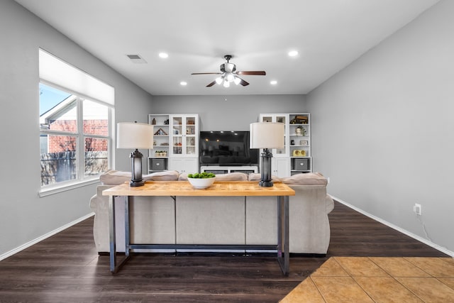 living room featuring ceiling fan and dark hardwood / wood-style flooring