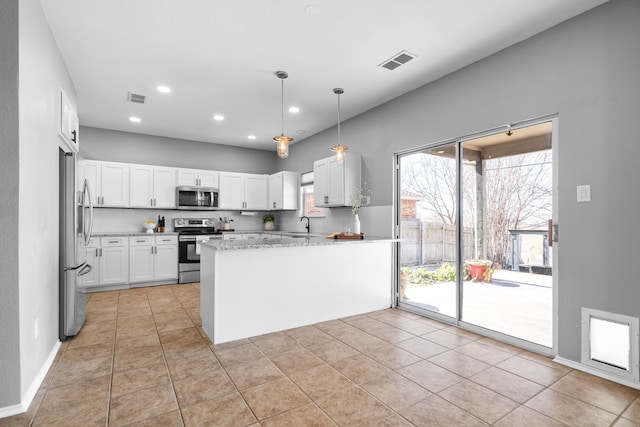 kitchen featuring tasteful backsplash, white cabinetry, kitchen peninsula, stainless steel appliances, and light tile patterned flooring