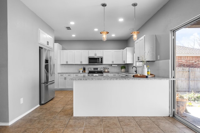 kitchen featuring appliances with stainless steel finishes, tasteful backsplash, white cabinetry, decorative light fixtures, and kitchen peninsula