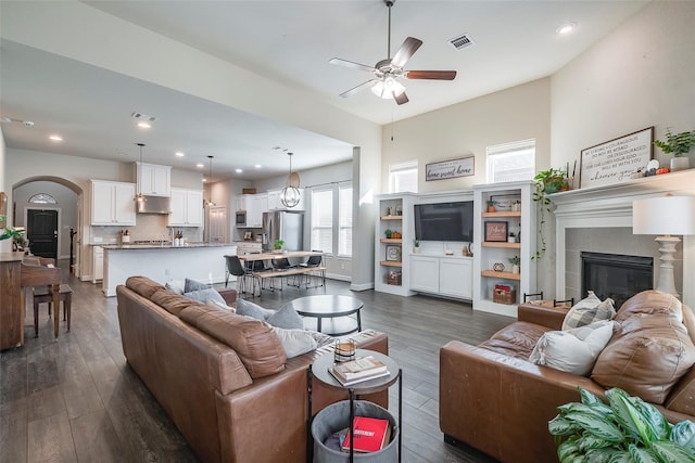 living room with ceiling fan, dark hardwood / wood-style flooring, and a fireplace