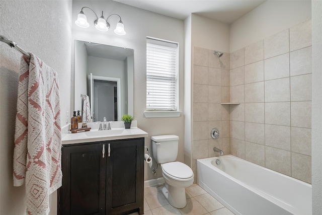 full bathroom featuring toilet, vanity, tiled shower / bath, and tile patterned flooring