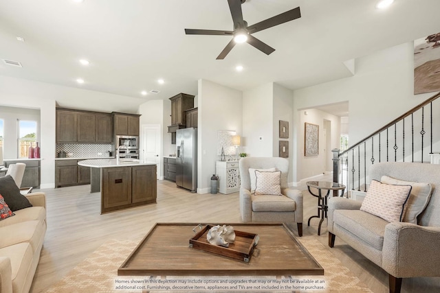 living room featuring light hardwood / wood-style floors and ceiling fan