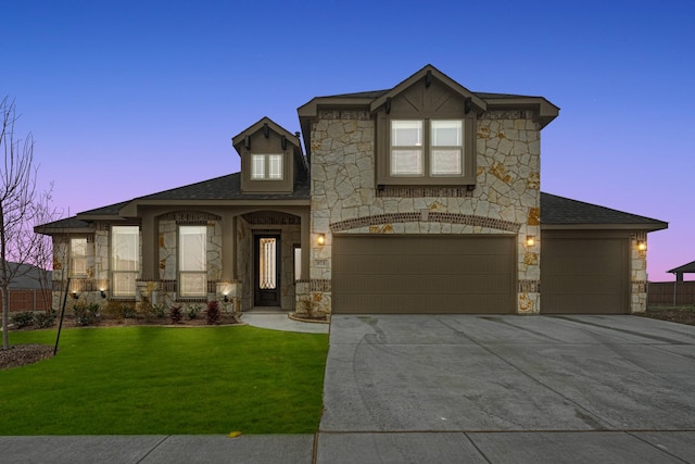 view of front of property featuring a garage and a lawn