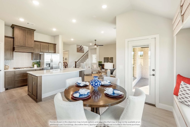 dining room with light hardwood / wood-style floors, lofted ceiling, and a healthy amount of sunlight