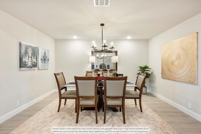 dining area with an inviting chandelier and light hardwood / wood-style flooring