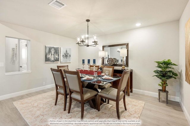 dining room featuring an inviting chandelier and light wood-type flooring