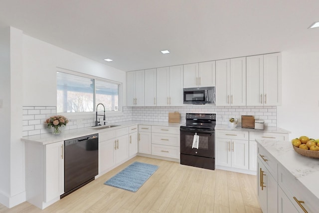 kitchen featuring black appliances, white cabinets, decorative backsplash, and sink